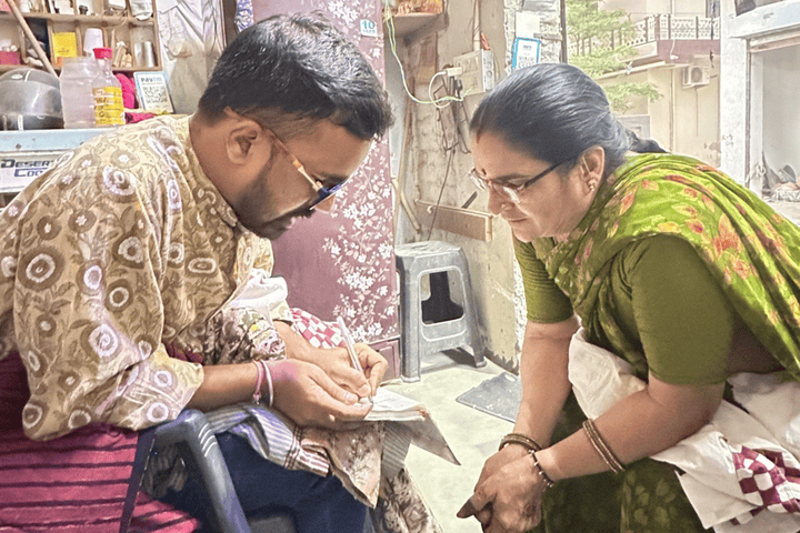 Artisan teaching traditional fabric printing techniques to a woman in Jaipur workshop
