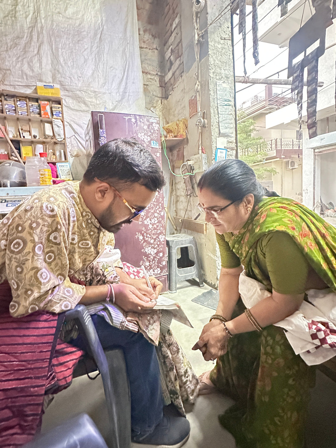 Artisan teaching traditional fabric printing techniques to a woman in Jaipur workshop